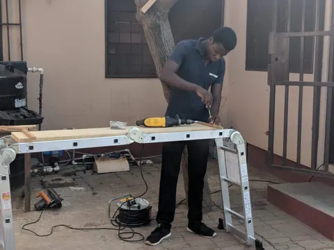 Technician preparing pipe sections on a work bench inside a building