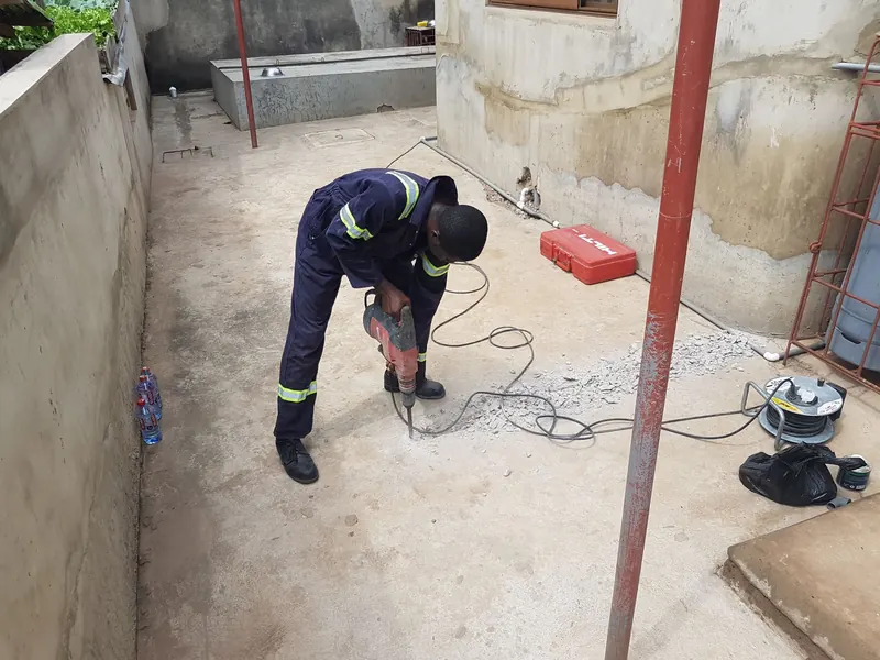 Technician opening a concrete floor for drainage works